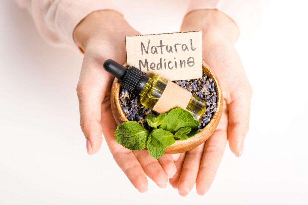 cropped image of woman holding bowl with essential oil and natural medicine sign isolated on white 1536x1025 1